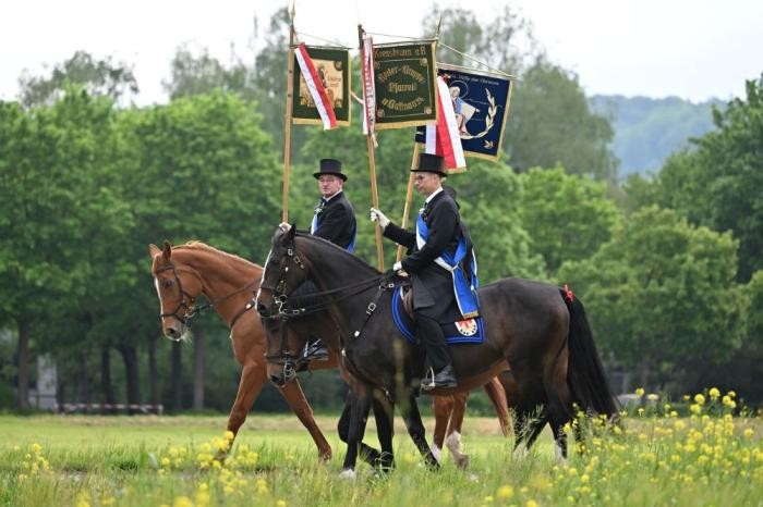 Zwei Reiter mit Standarten, während der Prozession alleine unterwegs in den Feldern und Fluren