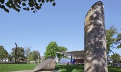 Blick auf das Kunstwerk "Tropenstamm" und das Pavillon im grünen Stadtgarten 
